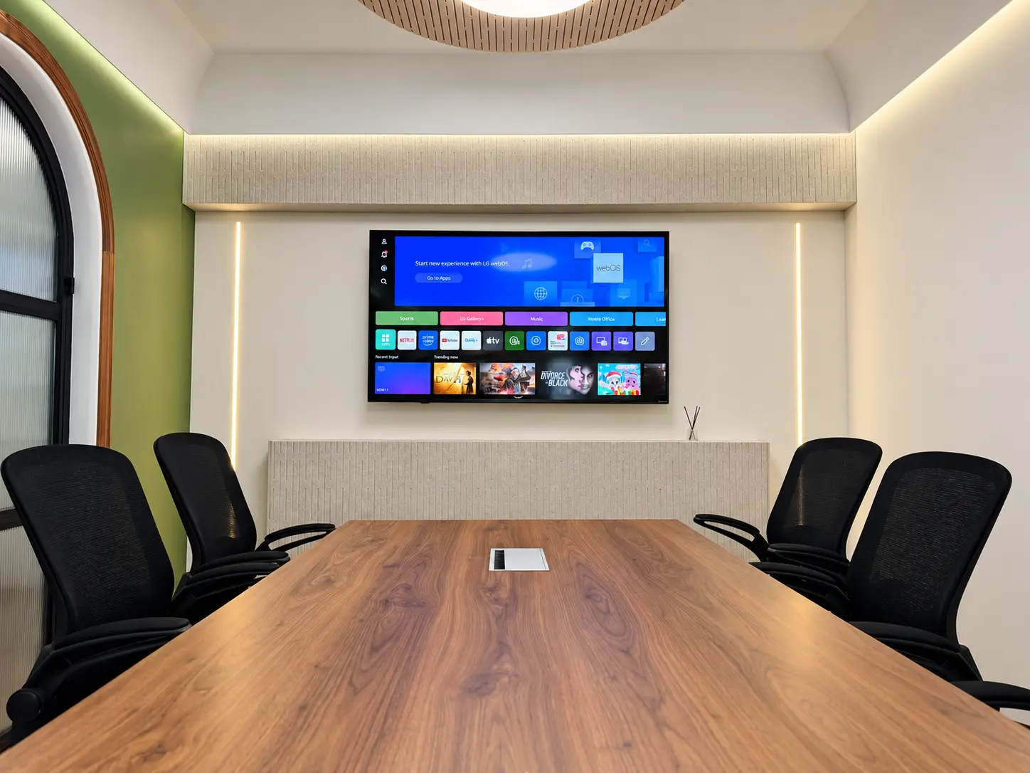 Sleek Fit Studio boardroom with walnut table, acoustic detailing and integrated screen