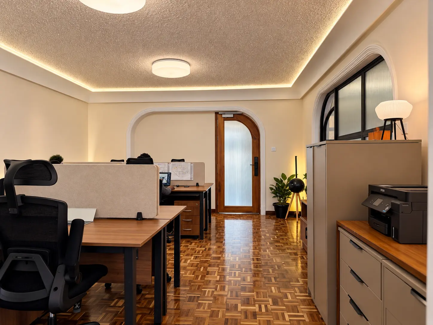Open studio floor with walnut desks, acoustic screens and parquet flooring