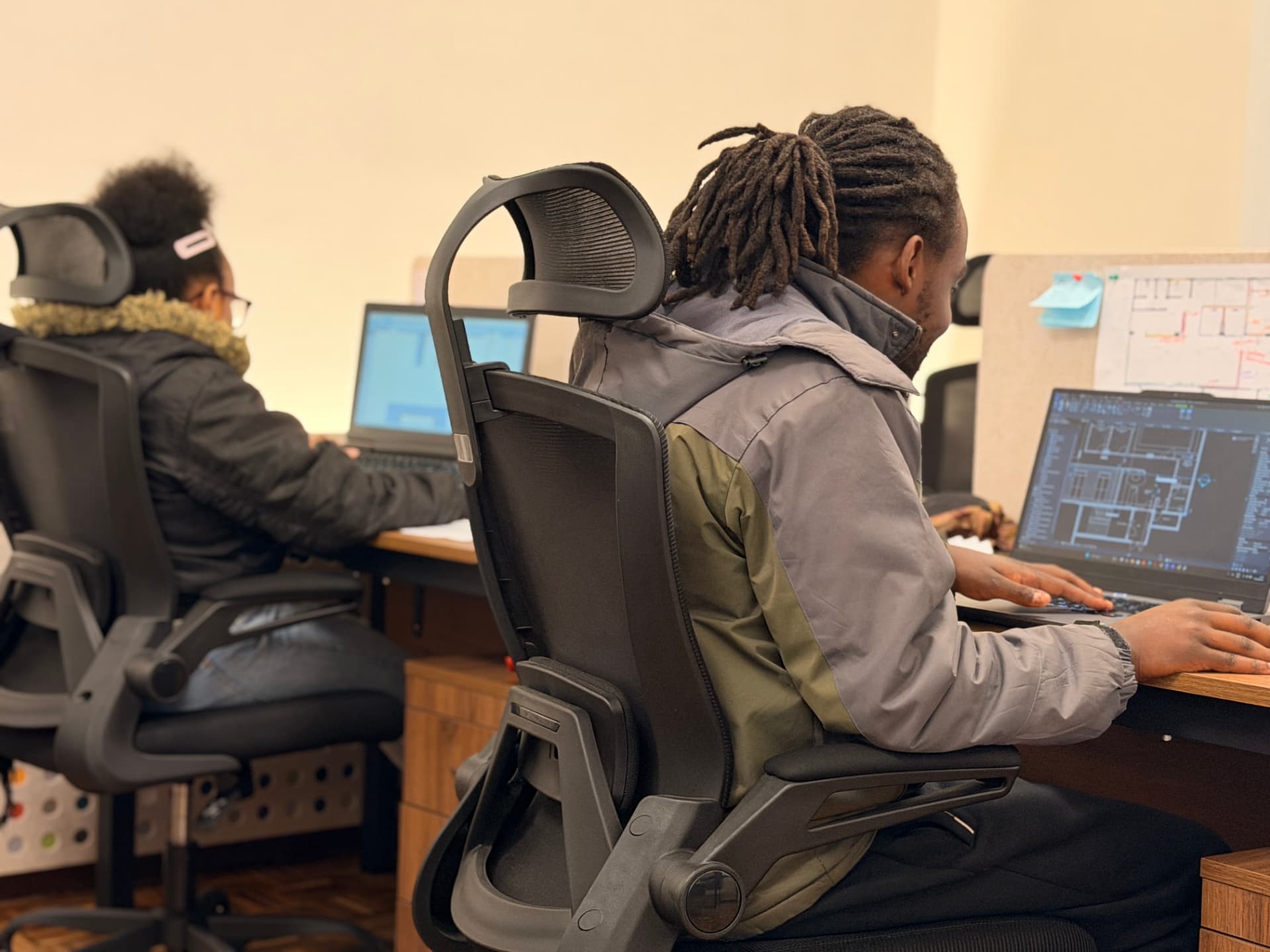 Sleek Fit Studio team members developing technical drawings at their workstations